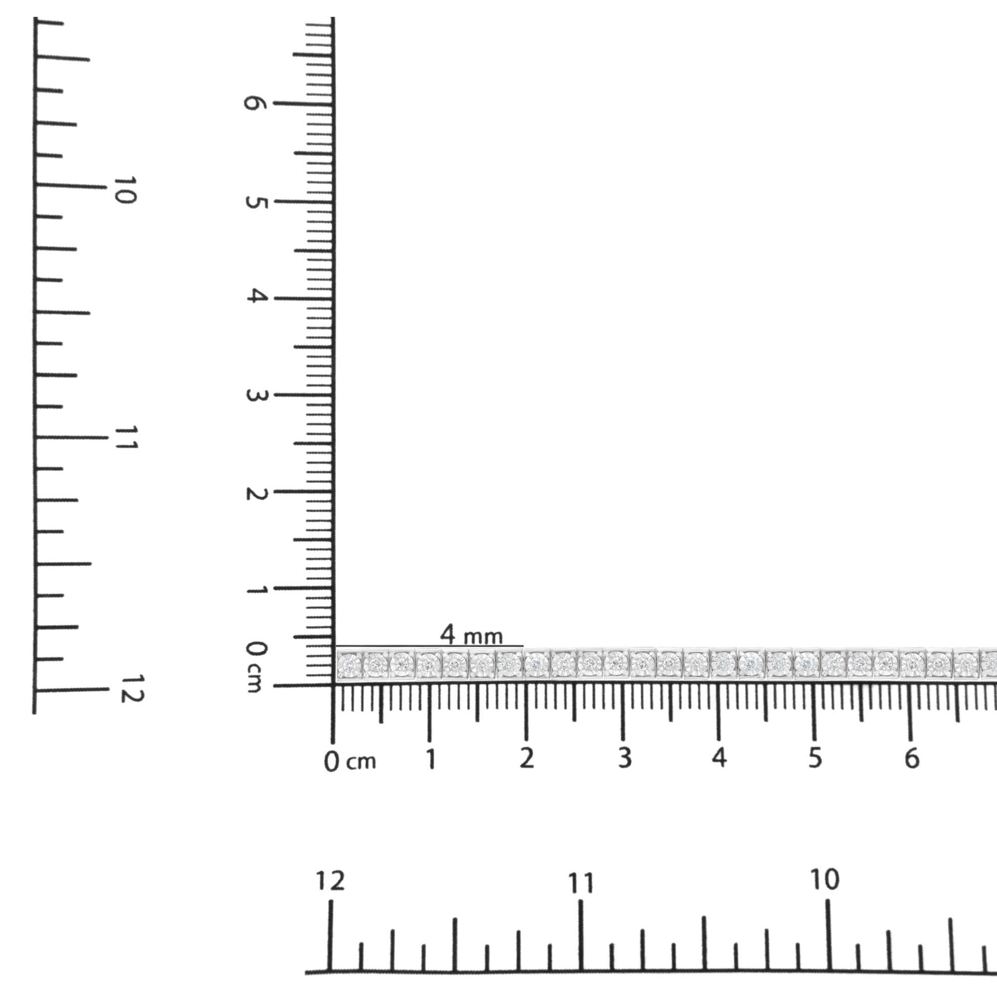 White metal bracelet with round white gemstones in miracle setting, placed flat on intersecting rulers for size reference, top-down angle.