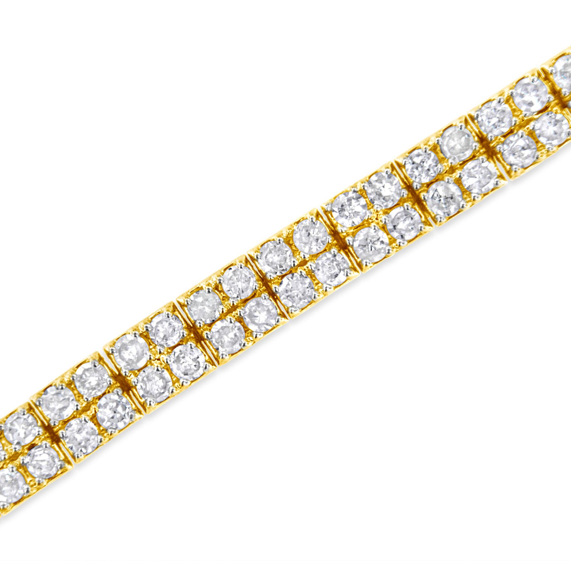 Close-up angled view of a yellow metal bracelet set with multiple round white gemstones in prong settings.