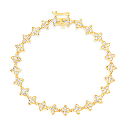 Top-down view of a yellow metal bracelet with flower-shaped links, each set with multiple round white gemstones in prong settings.