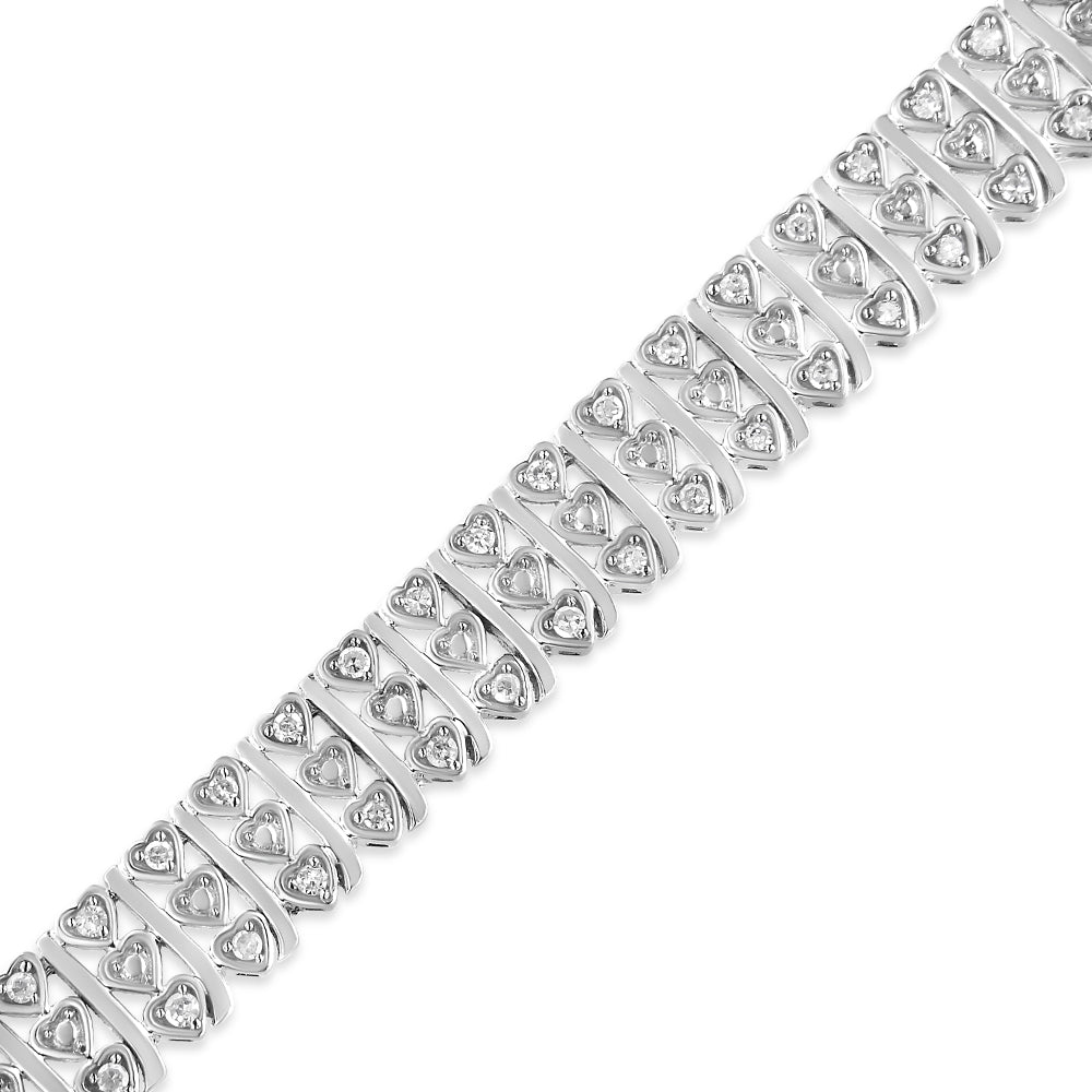 White metal bracelet with alternating heart-shaped links each set with a round white gemstone, shown in a close-up angled view.