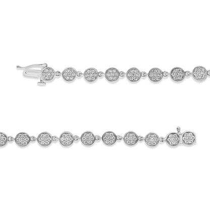 Close-up, horizontal shot of two white metal bracelets with round clusters of white gemstones in prong settings linked together.