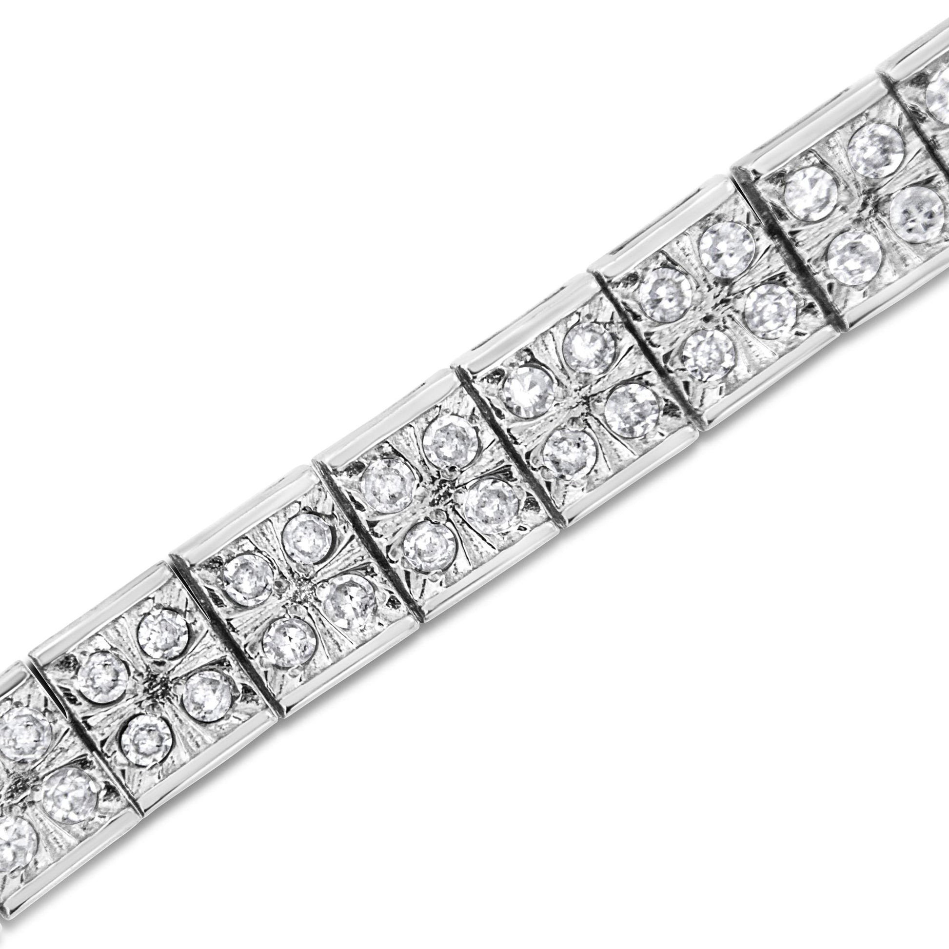 Close-up angled view of a white metal bracelet with square links, each set with multiple round white gemstones in prong settings.