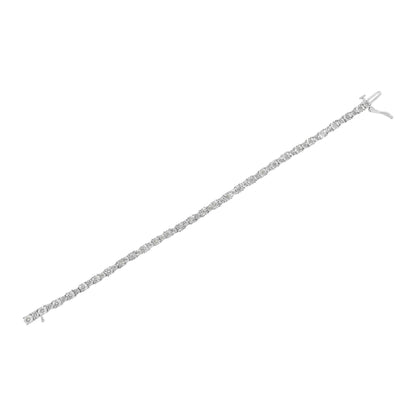 Diagonal top-down view of a white metal bracelet featuring a row of round white gemstones in a miracle setting.