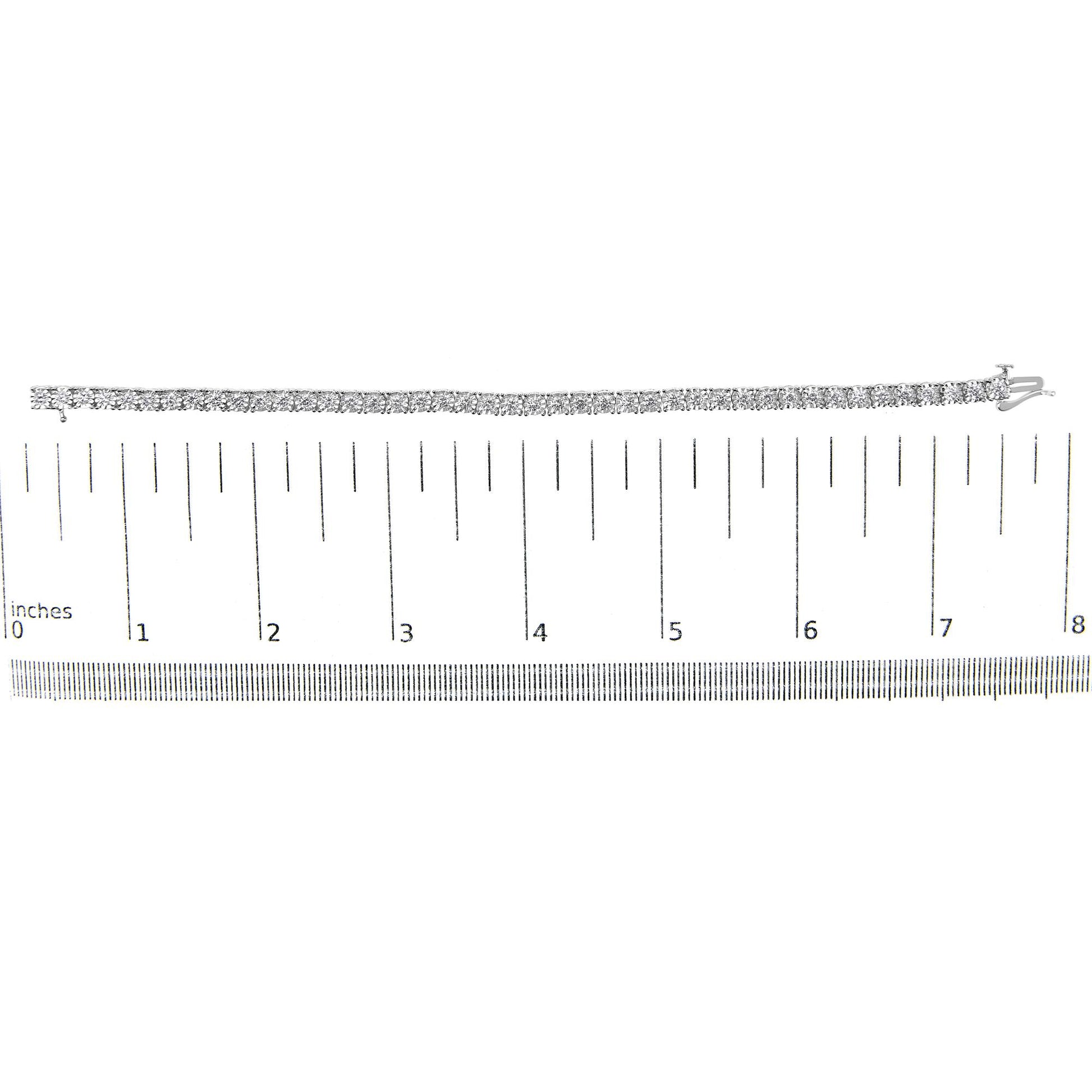 White metal bracelet with round white gemstones in miracle setting, displayed flat on a ruler for size reference, top-down angle.