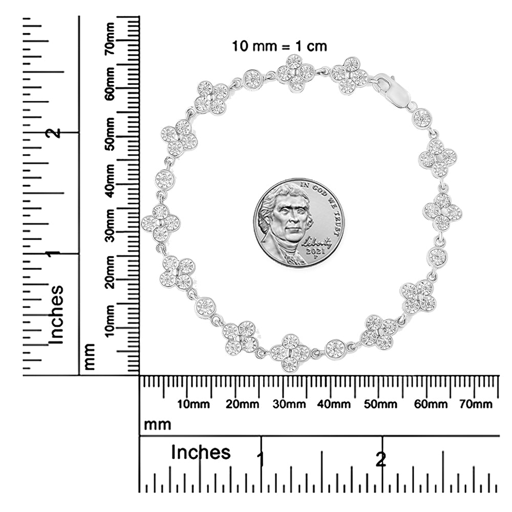 Top-down view of a white metal bracelet with round white gemstones in a miracle setting, featuring clusters of gemstones forming a floral pattern, displayed on a ruler for size reference with a coin inside the bracelet.