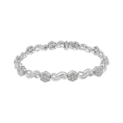 White metal bracelet with alternating floral clusters of round white gemstones in miracle setting and wavy links set with baguette white gemstones in channel setting, shown from a top angle against a white background.