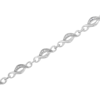 Diagonal close-up of a white metal bracelet featuring interconnected twisted links, each adorned with small round white gemstones in prong settings.