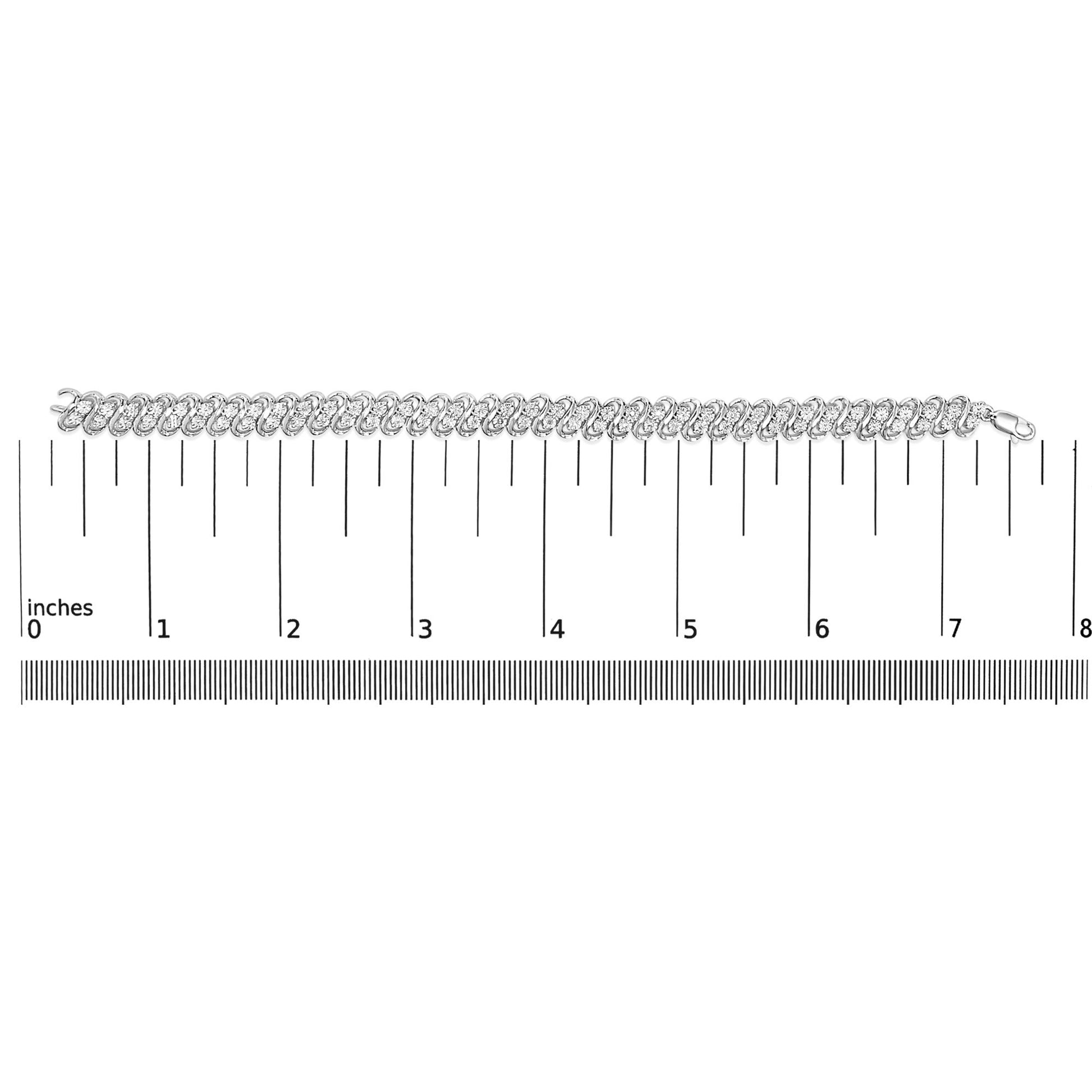 White metal bracelet with round white gemstones in miracle setting, laid flat on a ruler for size reference, top-down angle.