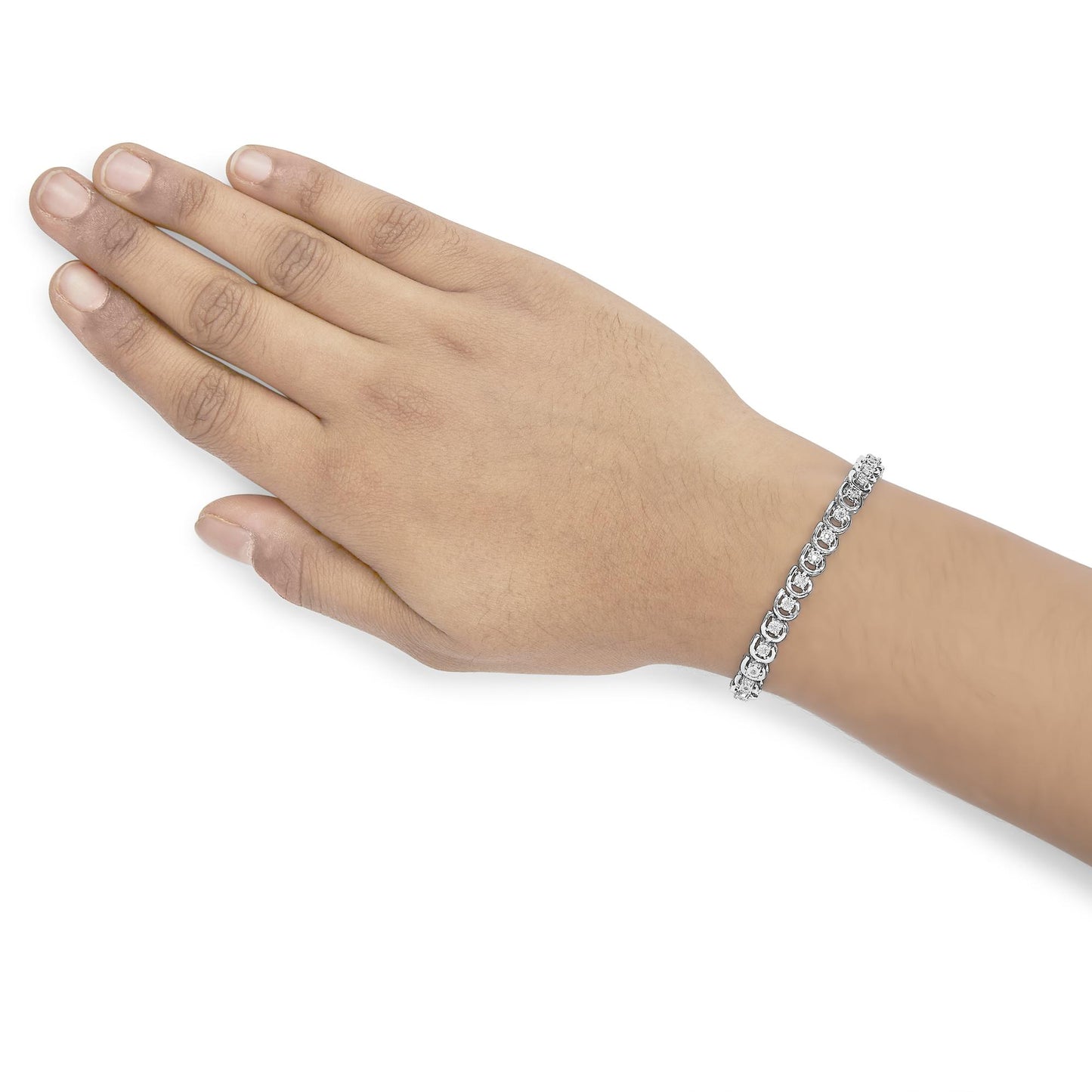 White metal bracelet with round white gemstones in miracle settings, worn on a model’s wrist, shown from a top angle.