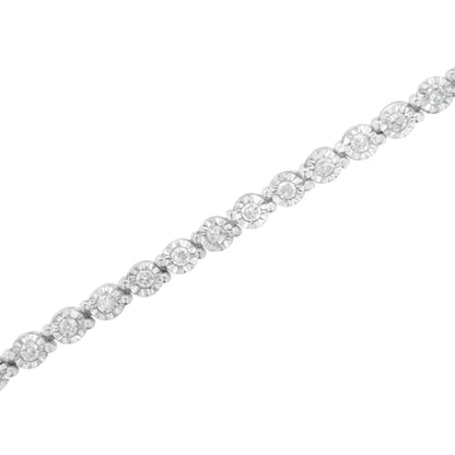 Diagonal close-up of a white metal bracelet featuring round white gemstones in a miracle setting.