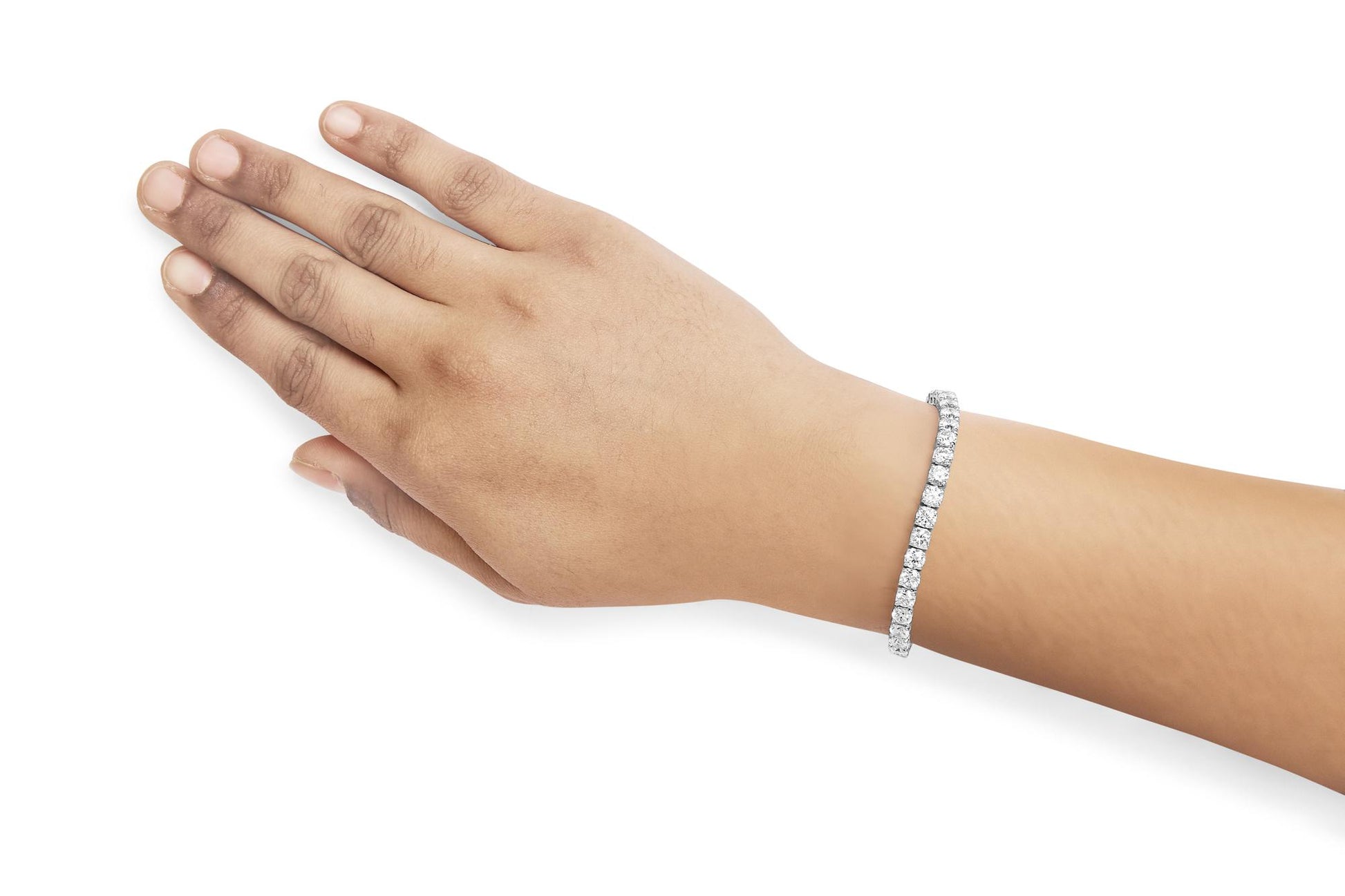 White metal bracelet with round white gemstones in 4-prong settings, worn on model's wrist, shown from top side angle.