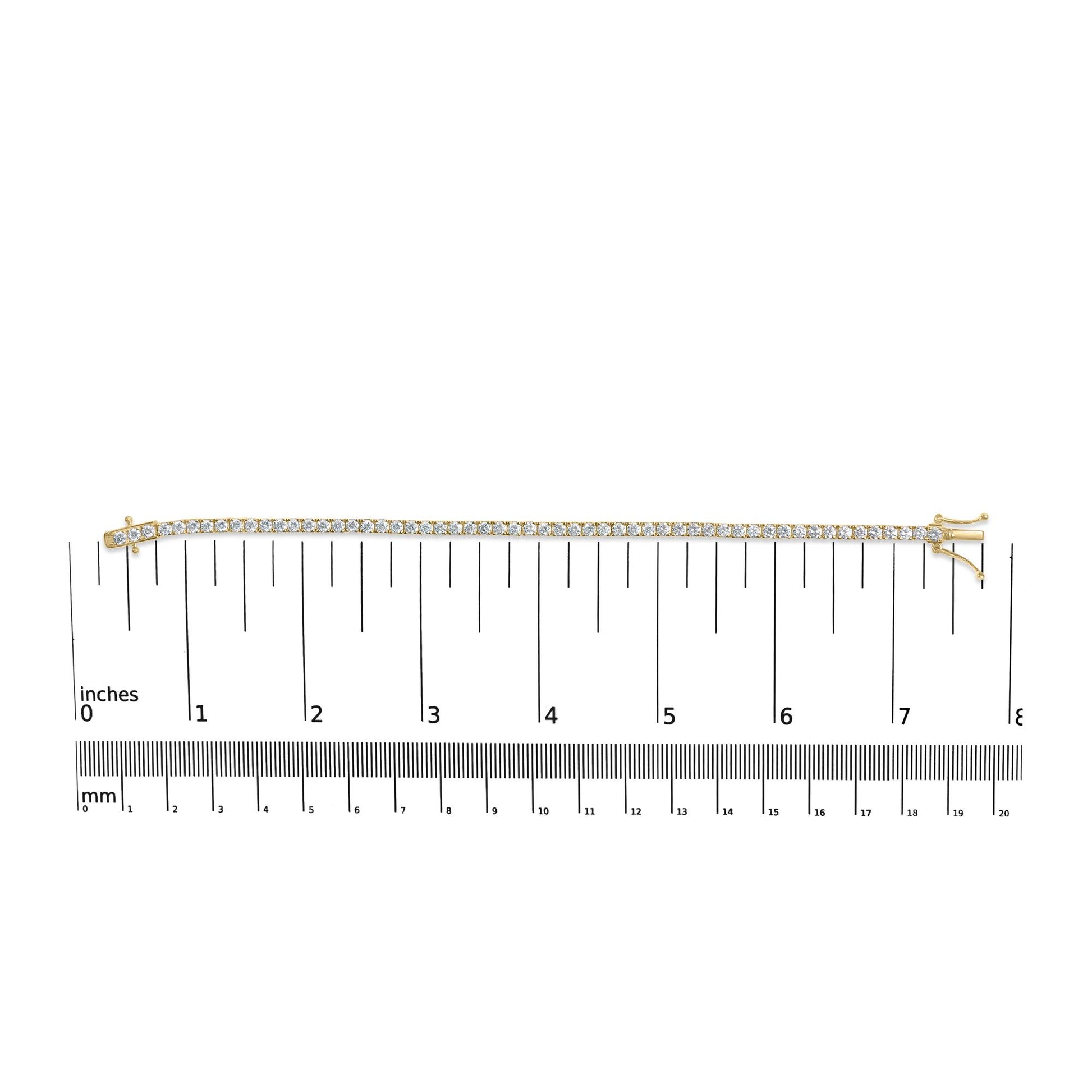 Yellow metal bracelet with round white gemstones in 4-prong settings, laid flat on a ruler for size reference, top-down view.