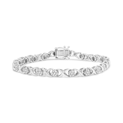 Bracelet in white metal with alternating round clusters of white gemstones set in prong settings, shown from a front angled view.