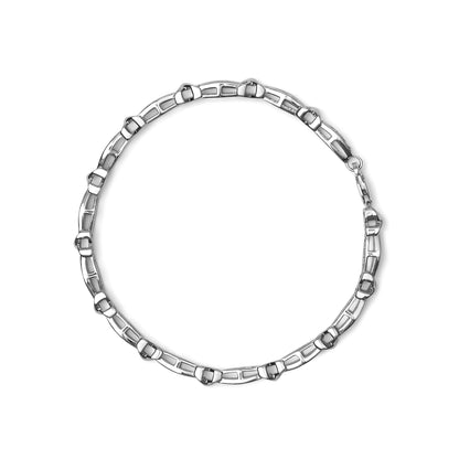 Top-down view of a white metal bracelet with linked rectangular segments and round white gemstones set in a miracle setting, with a clasp visible.