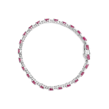Top-down view of a white metal bracelet featuring alternating rectangular red gemstones and round white gemstones in prong settings.