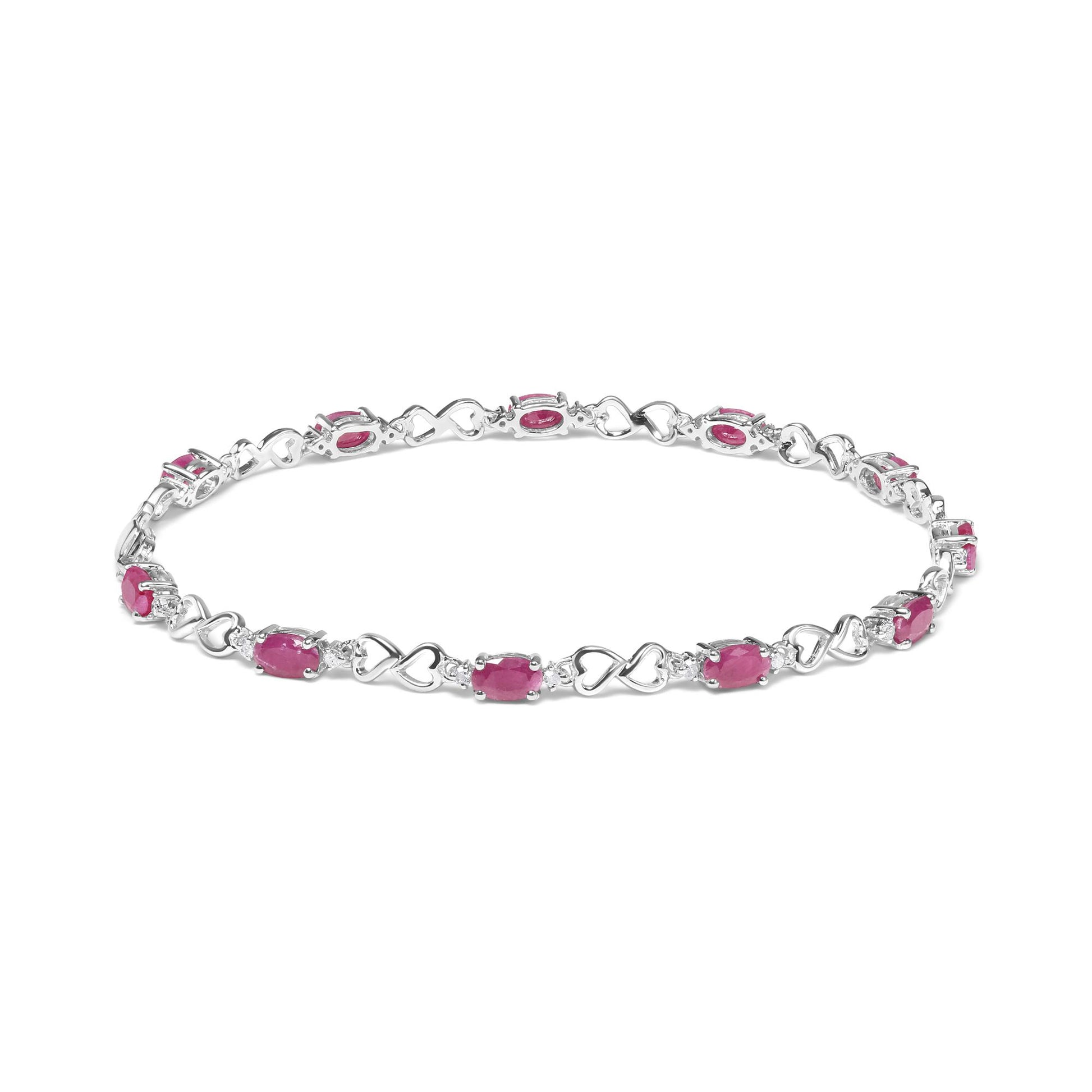 White metal bracelet with alternating heart-shaped links and oval pink gemstones, each separated by small round white gemstones, shown from a front angle.