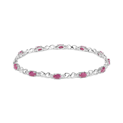 White metal bracelet with alternating heart-shaped links and oval pink gemstones, each separated by small round white gemstones, shown from a front angle.