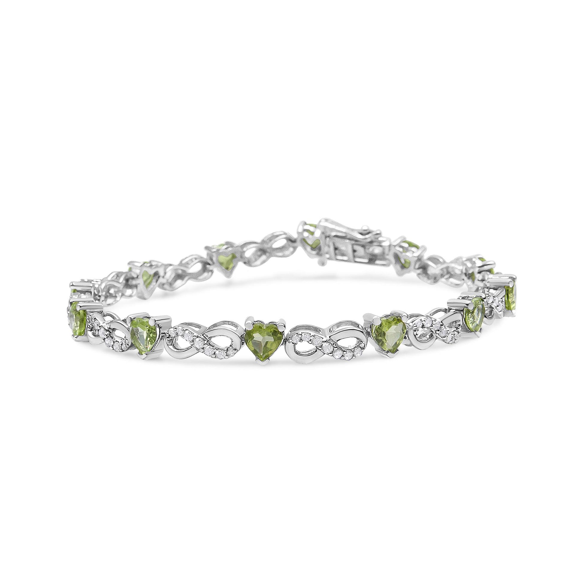 White metal bracelet with alternating heart-shaped green gemstones and infinity symbols set with small white gemstones, shown at a slight angle.