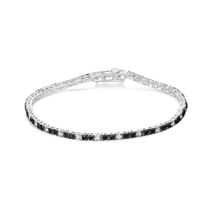 White metal bracelet with alternating black and white round gemstones in prong settings, shown flat from a top angle.