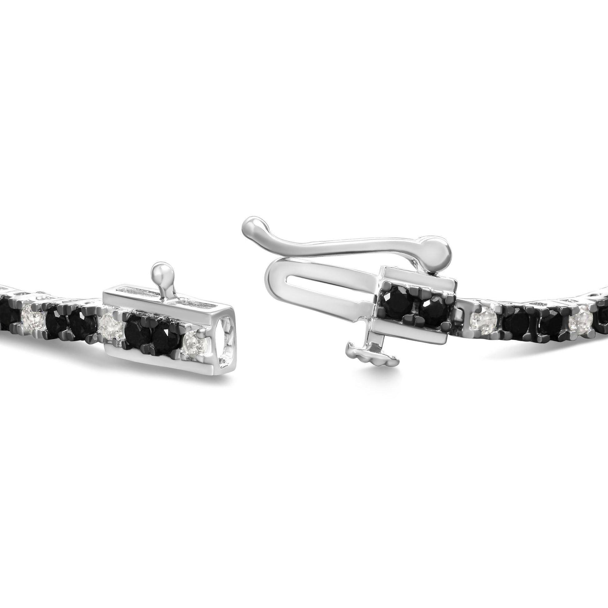 Close-up angled view of a white metal bracelet with alternating black and white round gemstones in prong settings, featuring a clasp mechanism.