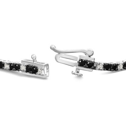 Close-up angled view of a white metal bracelet with alternating black and white round gemstones in prong settings, featuring a clasp mechanism.