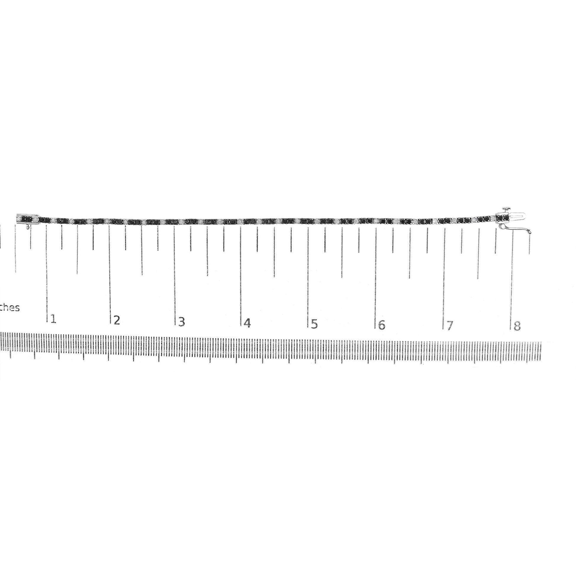 White metal bracelet with alternating black and white round gemstones in prong settings, shown flat on a ruler for size reference, top-down angle.
