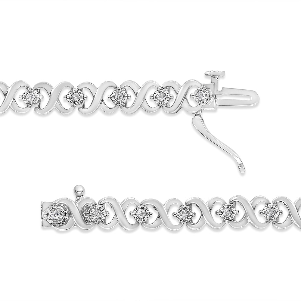 Close-up top view of a white metal bracelet featuring an alternating loop design with round white gemstones set in a miracle setting, shown unclasped on a white background.