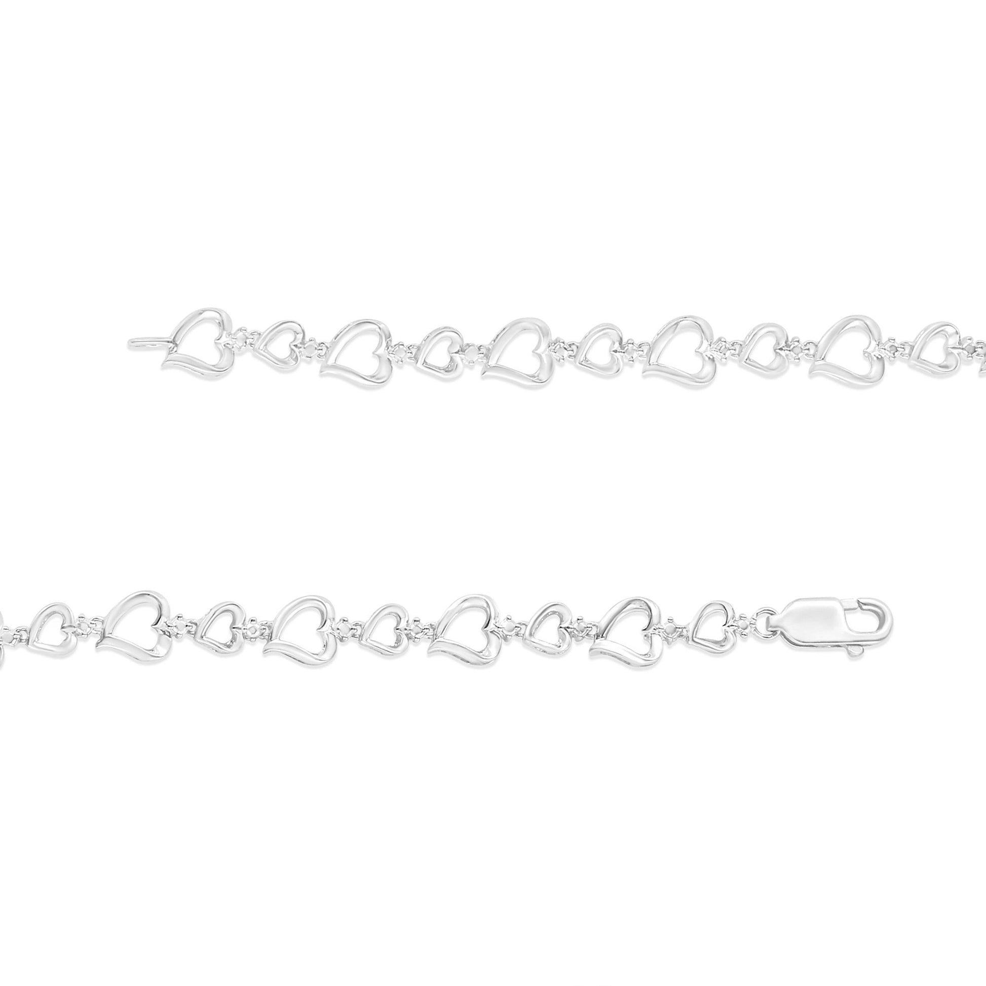 Top-down view of a white metal bracelet with alternating large and small open heart shapes connected by small links, each link featuring a white round gemstone in prong settings, shown on a white background.