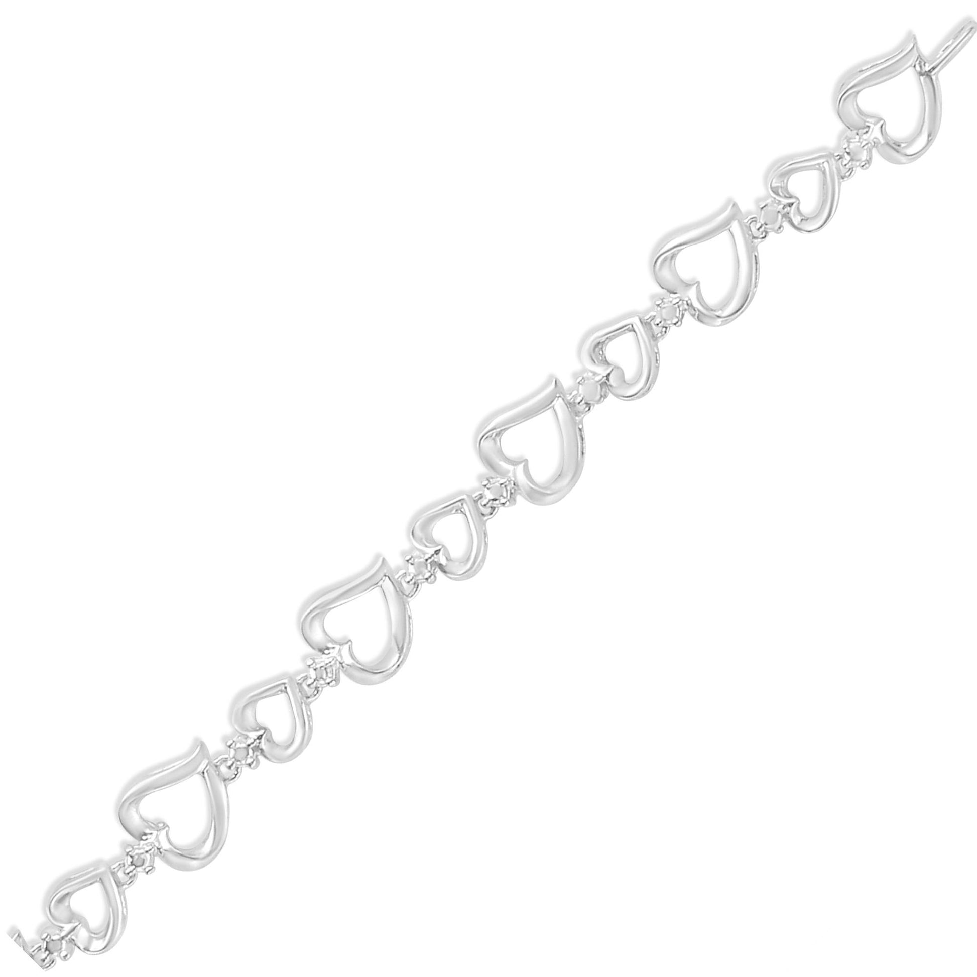 White metal bracelet with alternating open heart shapes connected by small links, each link set with a round white gemstone, shown in a flat diagonal top-down view.