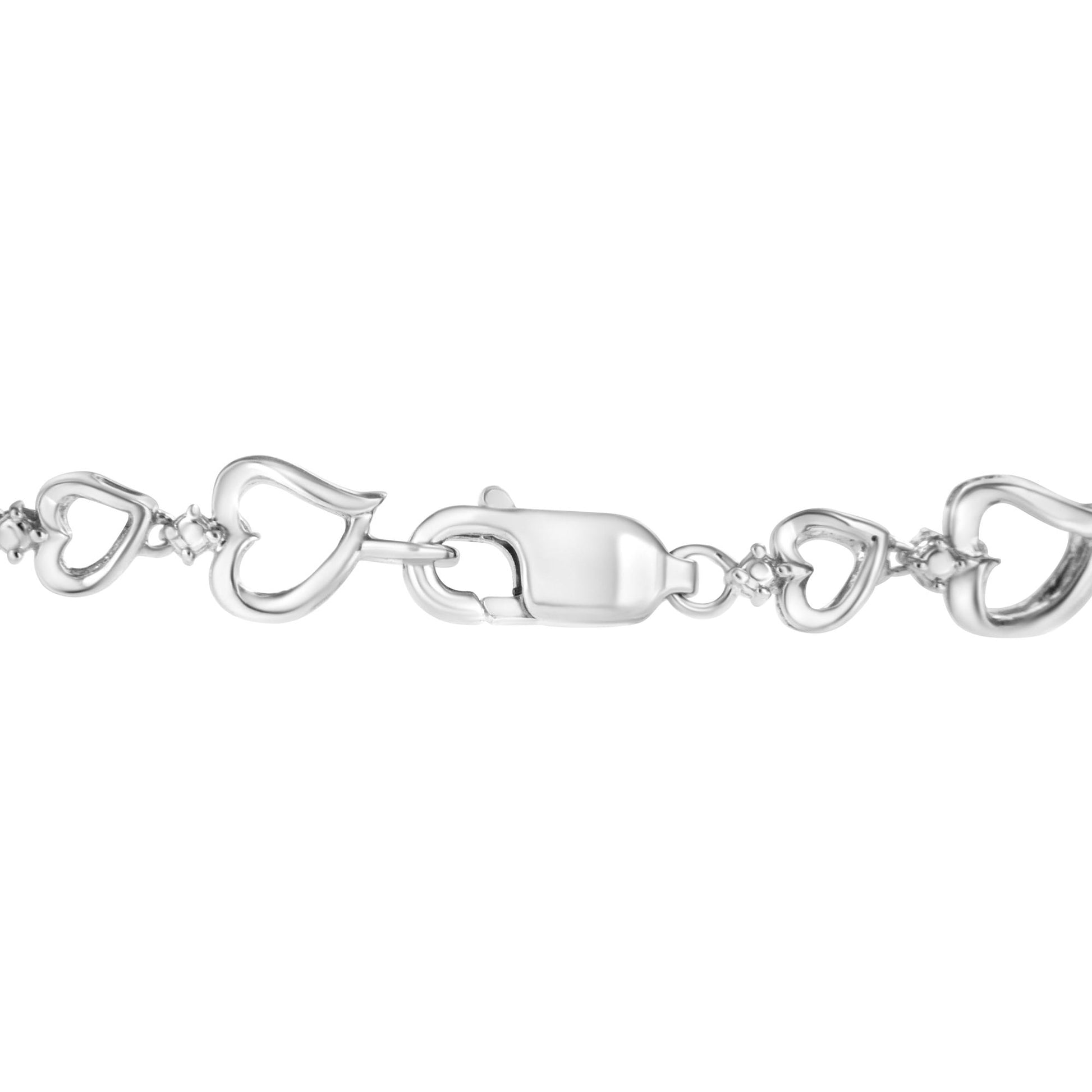 Close-up front angle of a white metal bracelet featuring linked open heart shapes with small white gemstones between them and a lobster clasp closure.