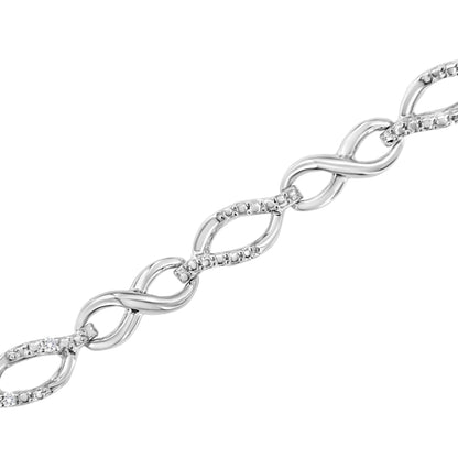 Close-up angled view of a white metal bracelet featuring intertwined links with small white gemstones and two round white prong-set gemstones.