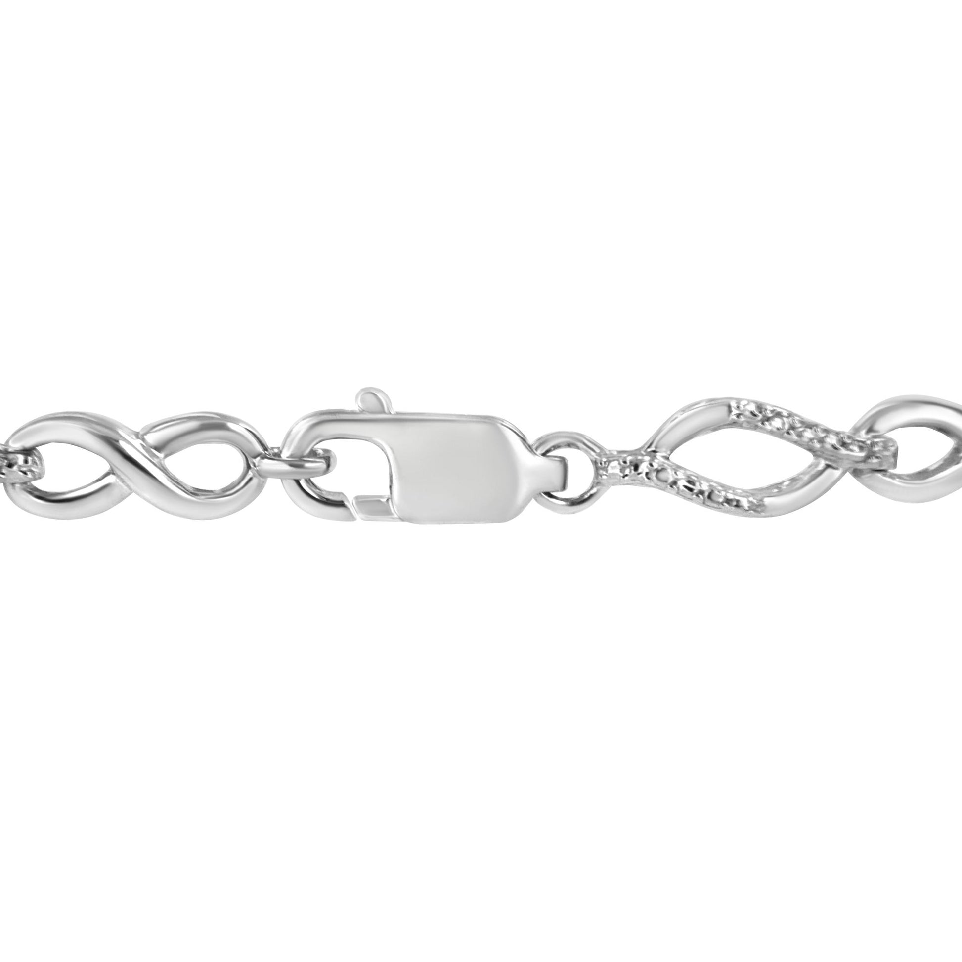 Close-up front angle of a white metal bracelet featuring an infinity link design with two round white gemstones in prong settings near the clasp.