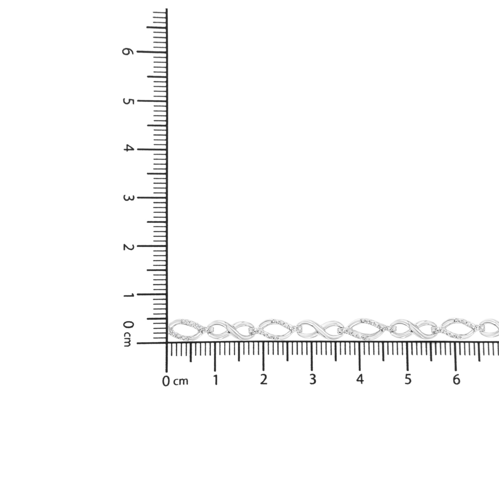 White metal bracelet with alternating twisted and oval links accented with small white gemstones, shown on a ruler for size reference from a top-down angle.