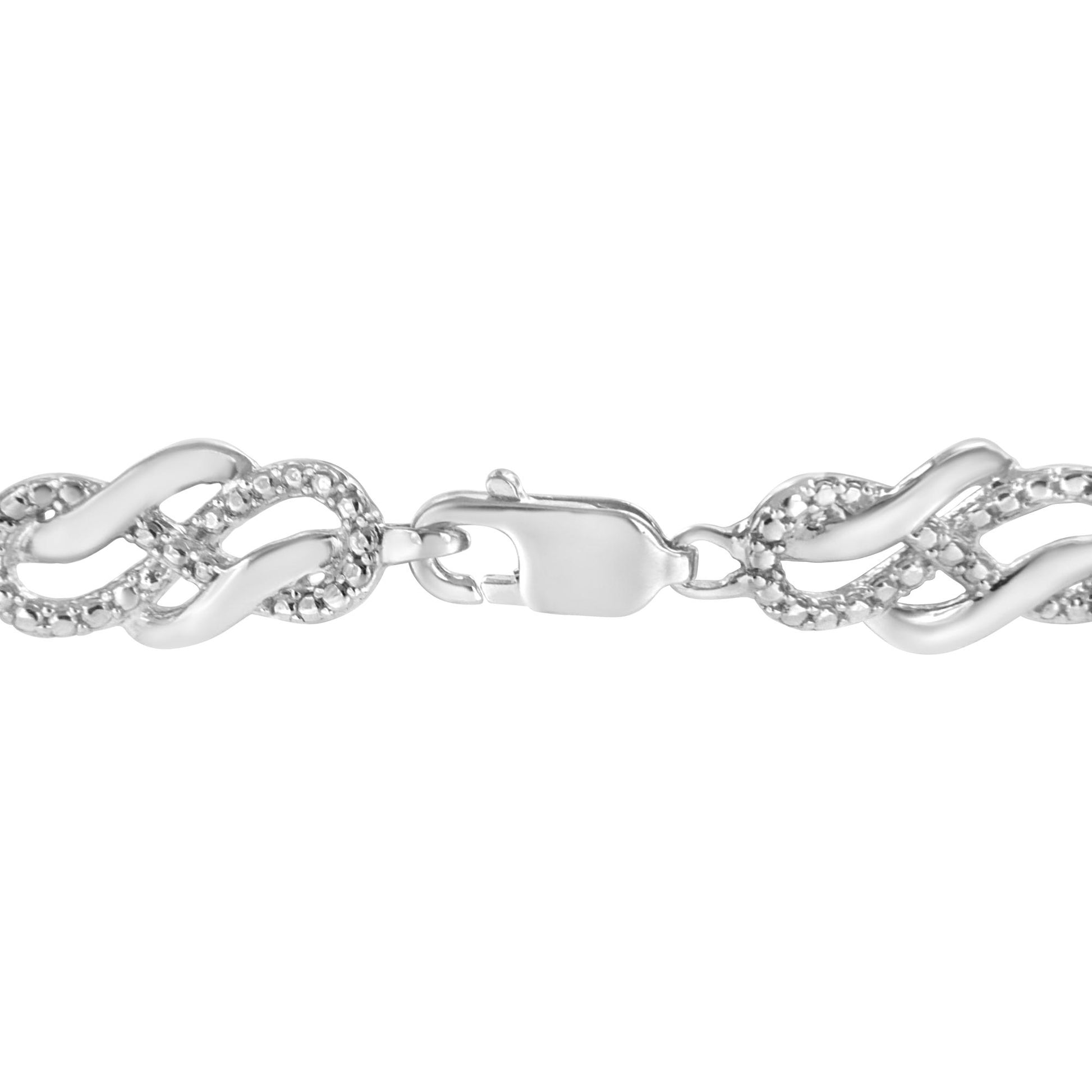 Close-up front view of a white metal bracelet with interlocking wave-shaped links, accented with small white round gemstones in prong settings, shown on a white background.