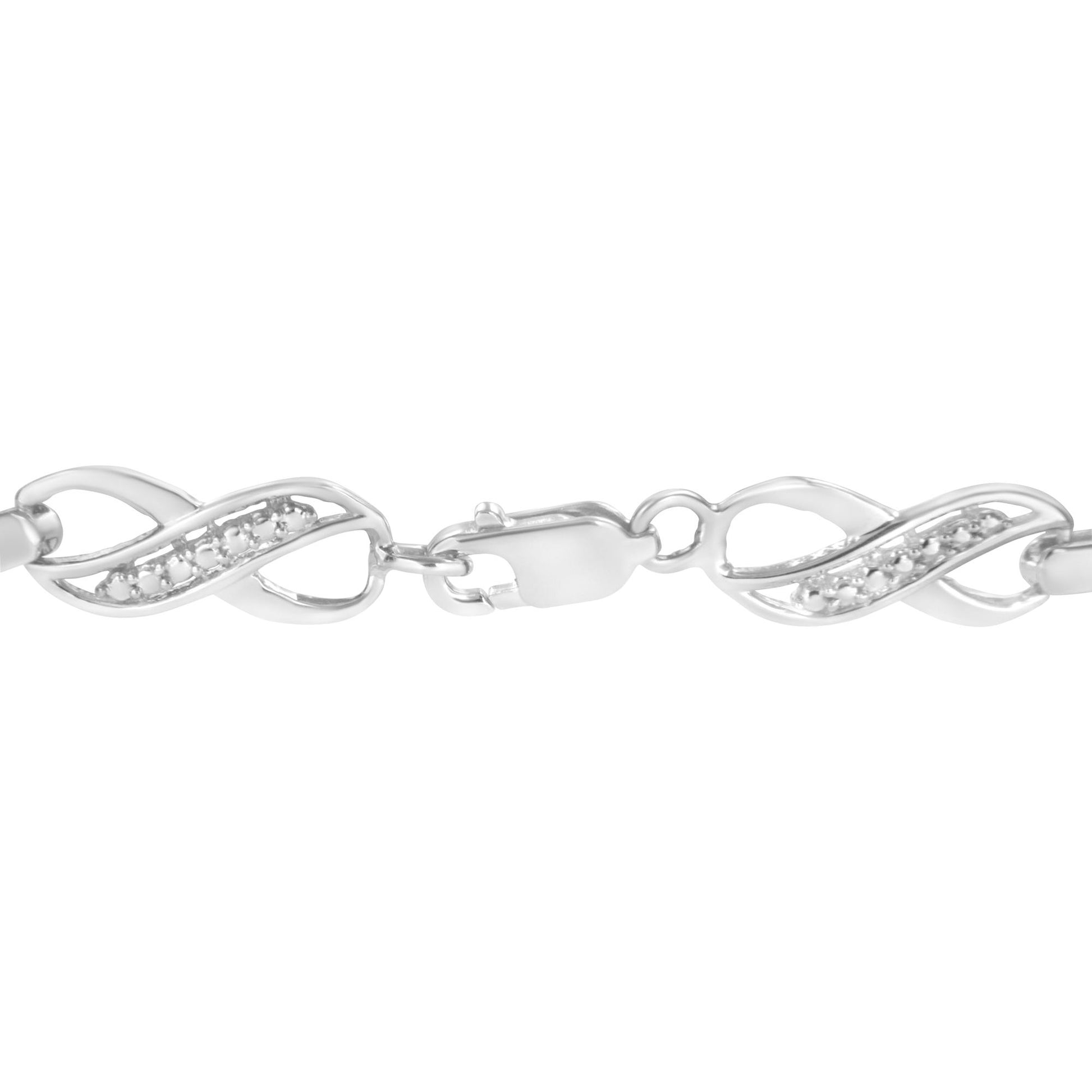 Close-up front view of a white metal bracelet with an infinity-inspired design, featuring small white gemstones set along the curves and a lobster clasp closure.
