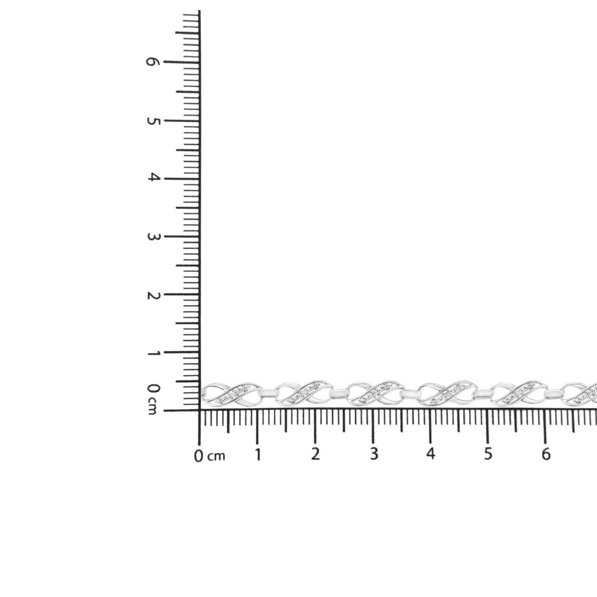 White metal bracelet with twisted links featuring small white gemstones, displayed on ruler for size reference, top-down angle.