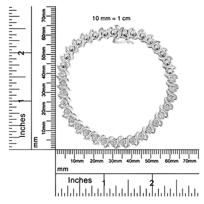Top-down view of a white metal bracelet with round white gemstones in a miracle setting, placed on rulers for size reference.