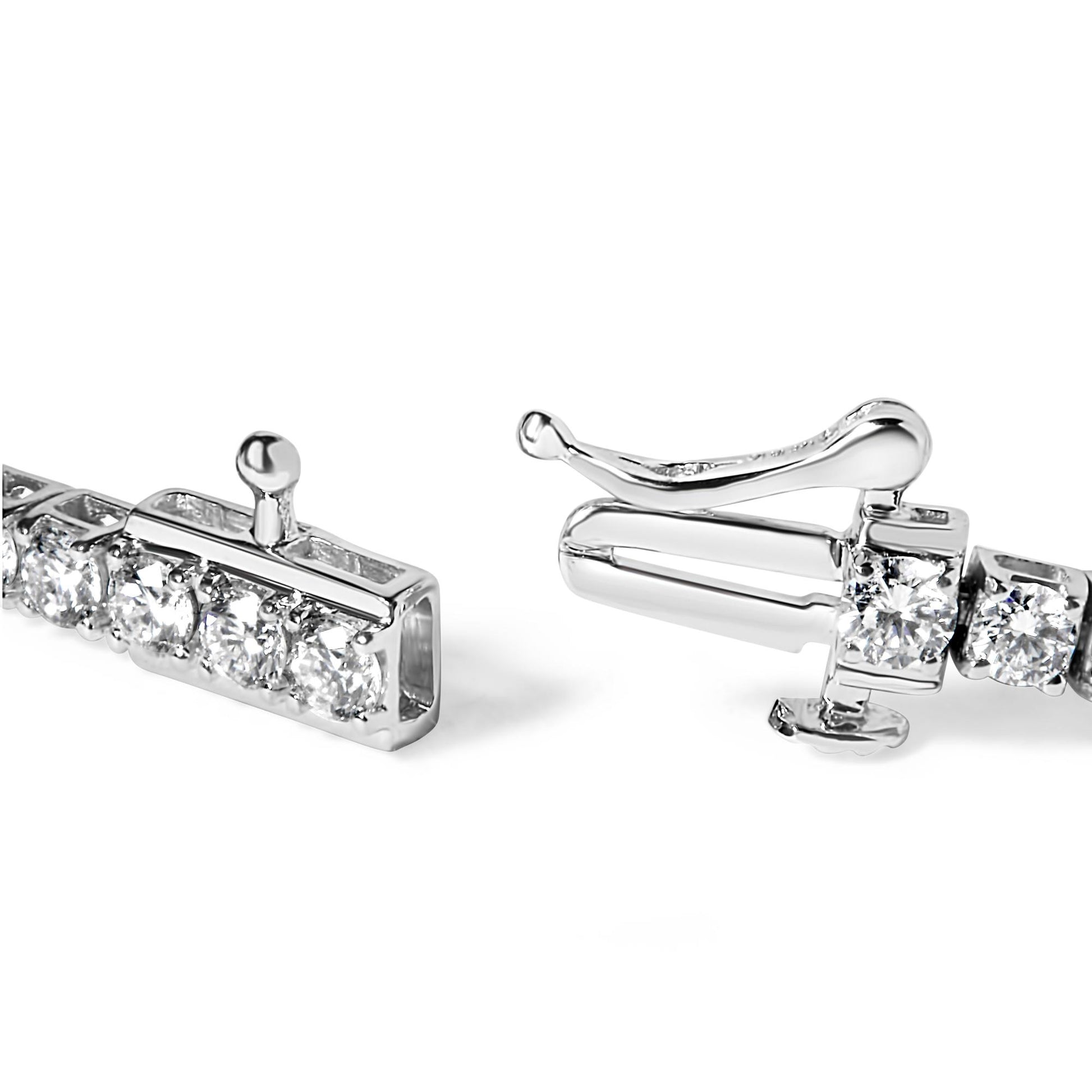 Close-up angled view of a white metal bracelet with round white gemstones in four-prong settings and a clasp mechanism.