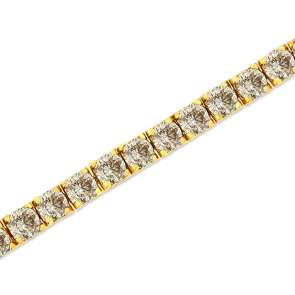 Close-up diagonal shot of a yellow metal bracelet with round brownish gemstones in prong settings.