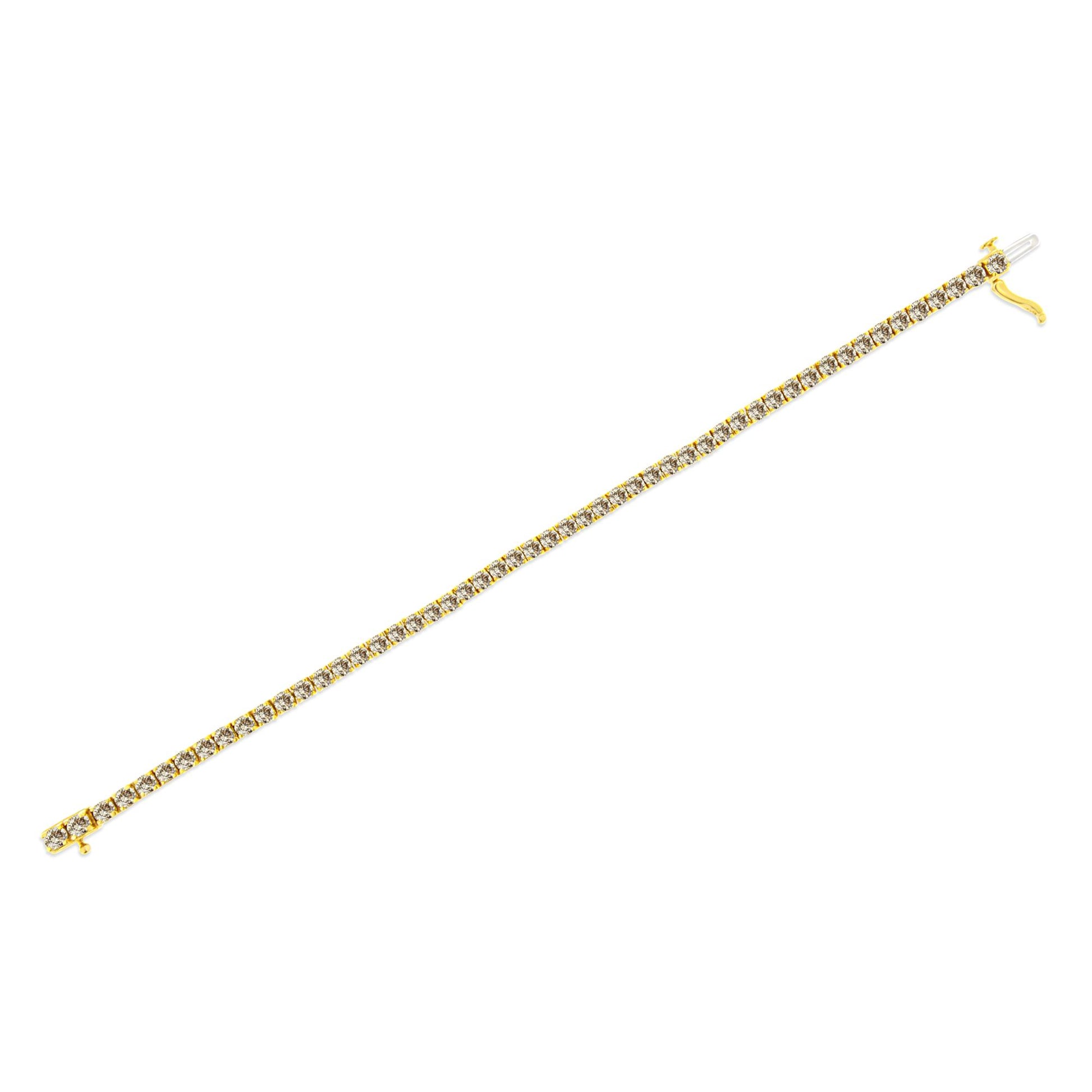 Yellow metal bracelet with a line of prong-set round white gemstones, shown flat on a white background at a slight diagonal angle.