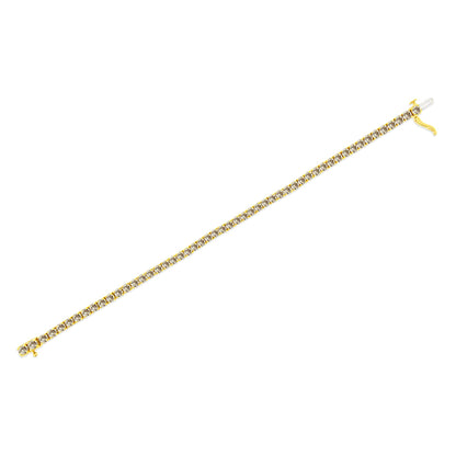 Yellow metal bracelet with a line of prong-set round white gemstones, shown flat on a white background at a slight diagonal angle.