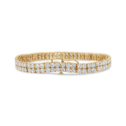 Yellow metal bracelet with round brownish gemstones in 4-prong settings, shown in a front angle shot on a white background.