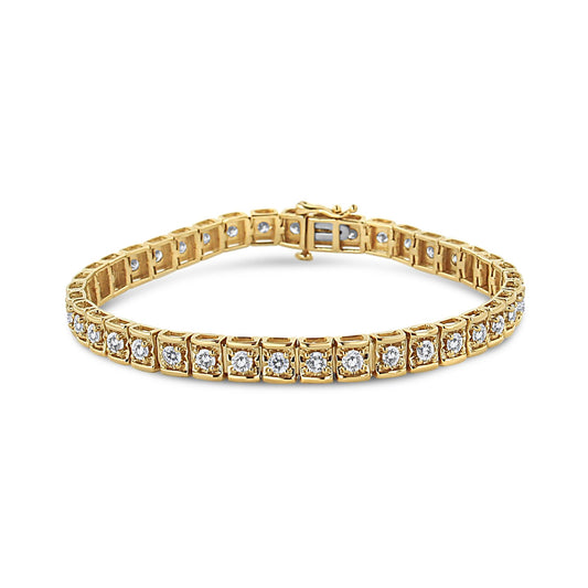 Close-up front angle view of a yellow metal bracelet with round brownish prong-set gemstones evenly spaced along its length.