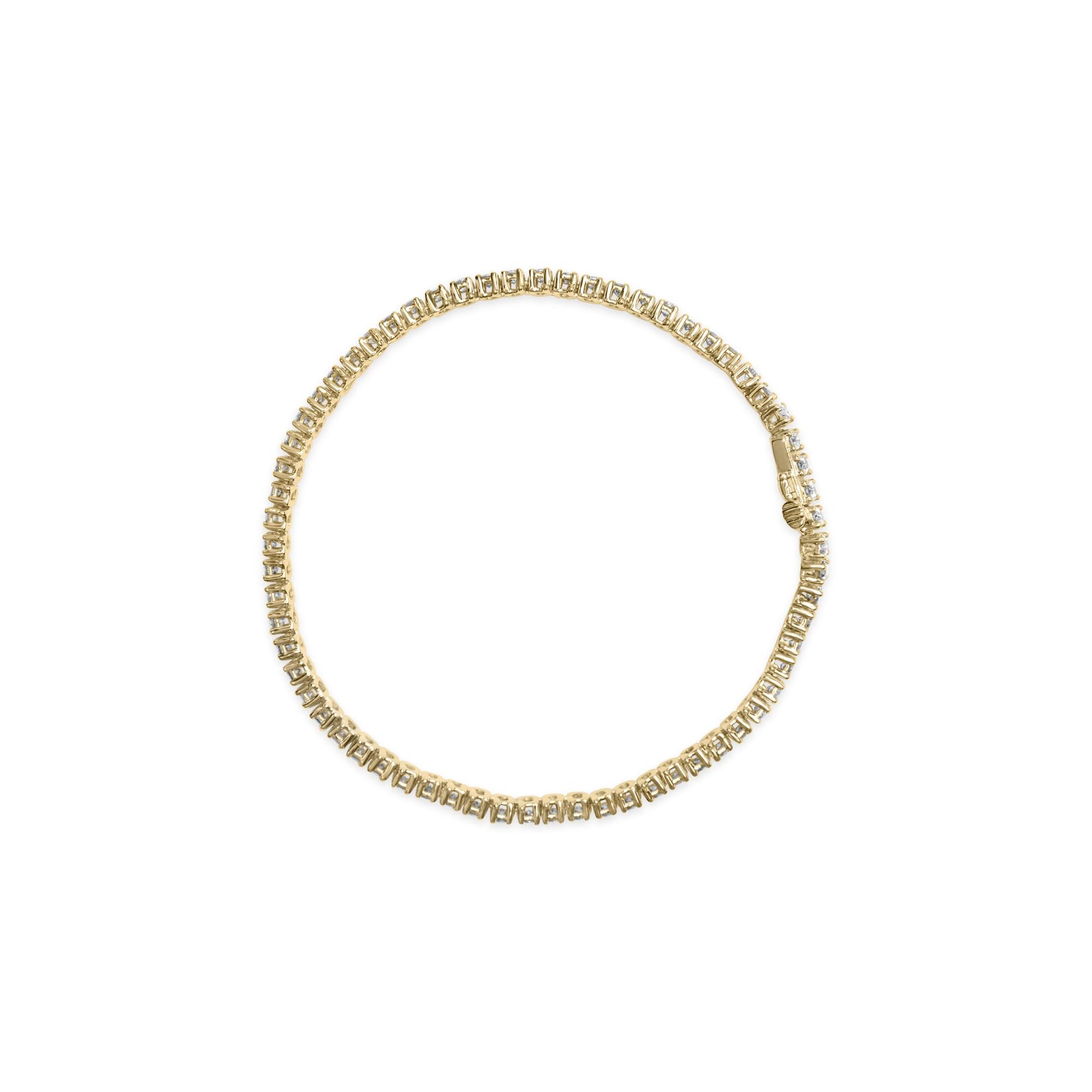 Top-down view of a yellow metal bracelet with round white gemstones in prong settings arranged in a continuous line forming a circle.