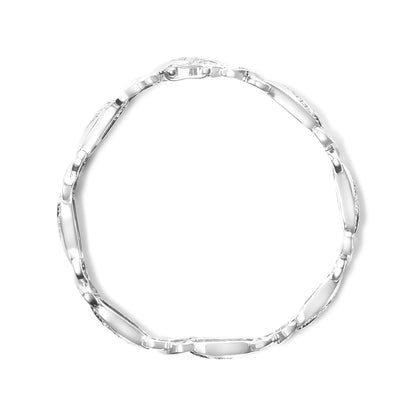 Top-down view of a white metal bracelet featuring round and baguette-shaped white gemstones in prong and channel settings.