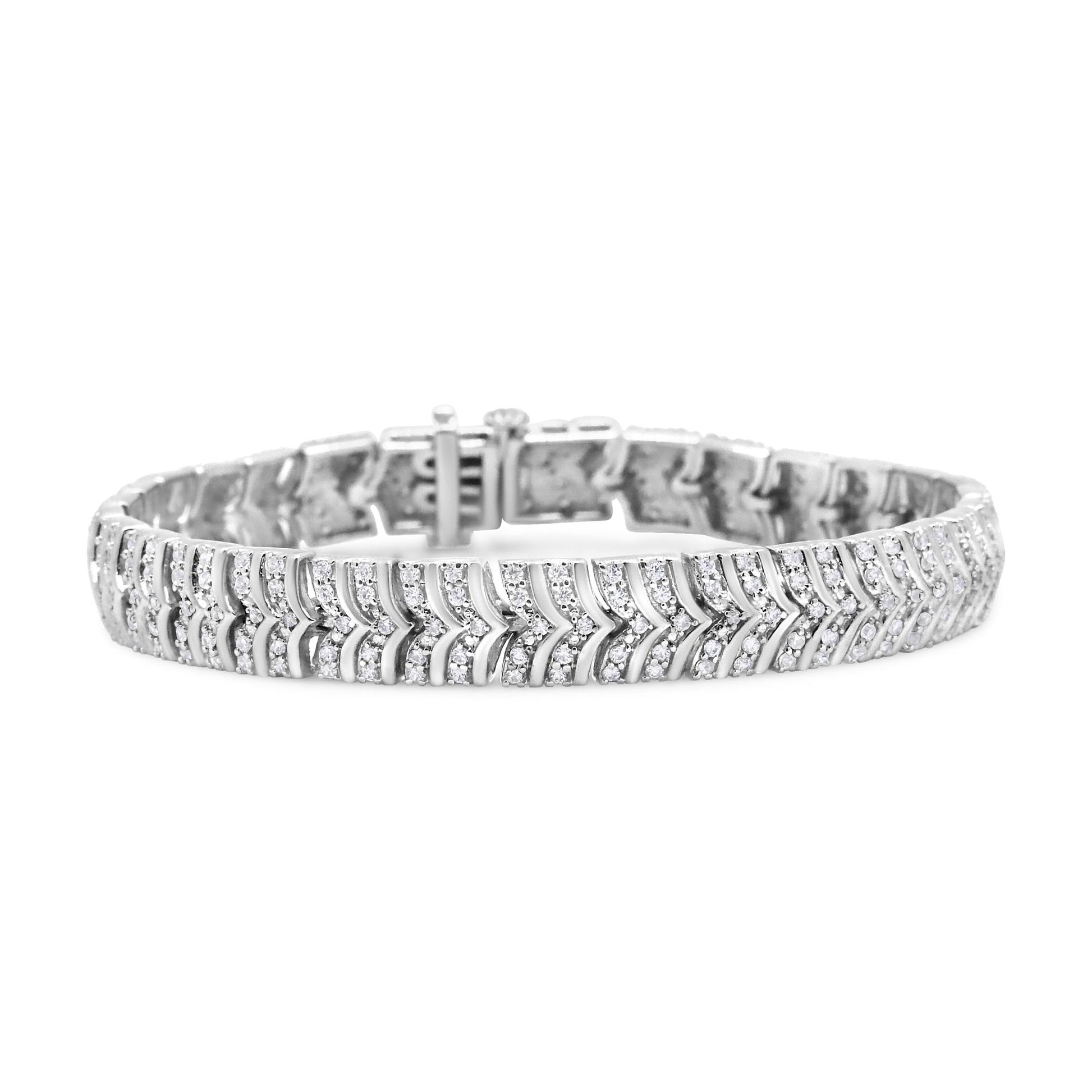White metal bracelet with pave set round white gemstones in a chevron pattern, shown from a front angled view.