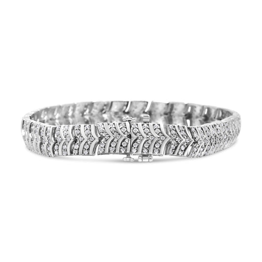 Close-up front angle of a white metal bracelet with a chevron pattern set with round white gemstones in pave setting.