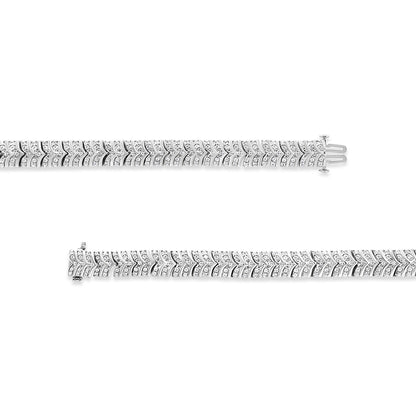 Top-down view of two white metal bracelets with chevron pattern, each set with multiple round white gemstones in pave setting.