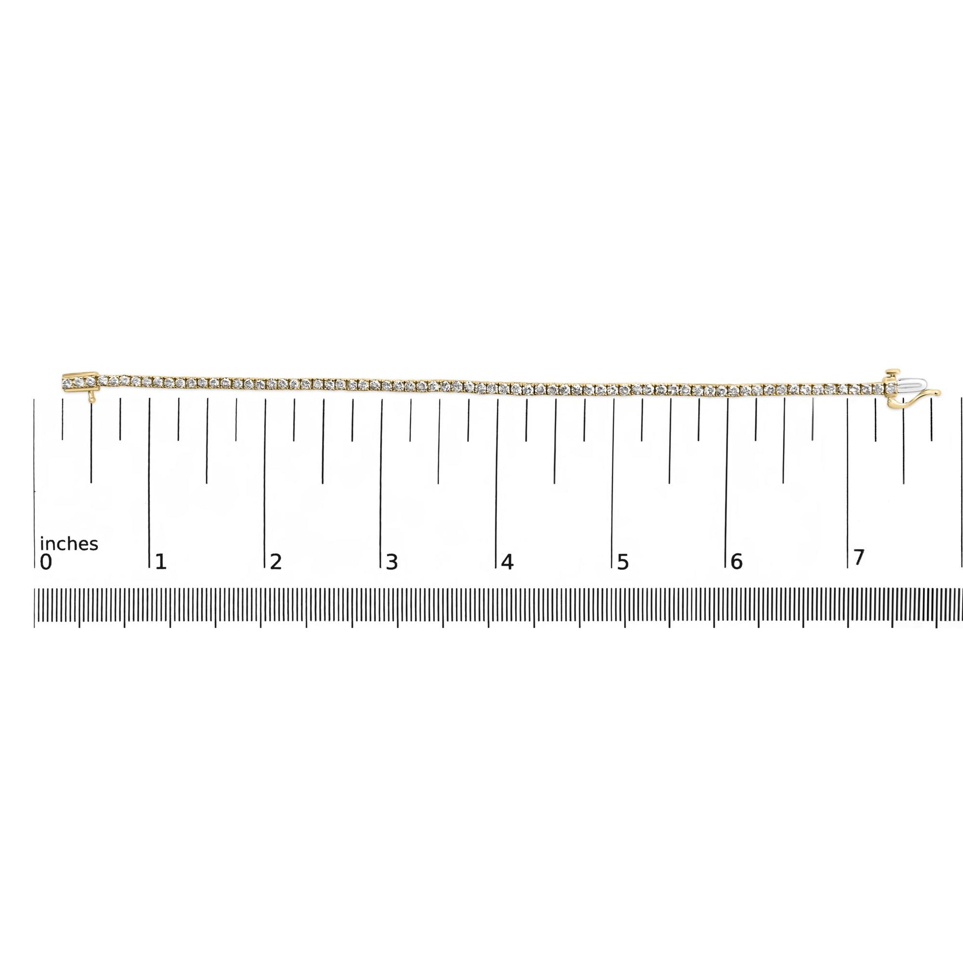 Yellow bracelet with round brownish gemstones in 4-prong settings, displayed flat on a ruler for size reference, top-down angle.