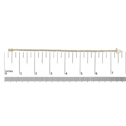Yellow bracelet with round brownish gemstones in 4-prong settings, displayed flat on a ruler for size reference, top-down angle.